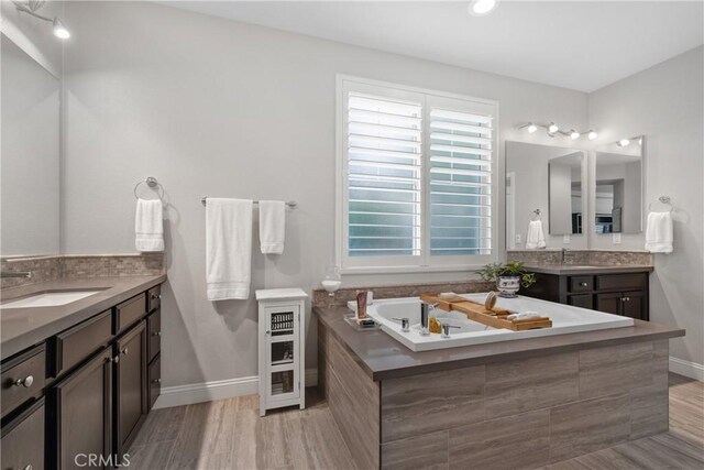 28934 Rangeview Dr, Murrieta, CA 92563 - full bathroom with baseboards, wood finished floors, vanity, and a tub