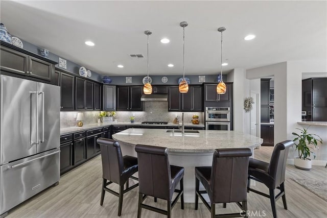 28934 Rangeview Dr, Murrieta, CA 92563 - kitchen with stainless steel appliances, a sink, light stone counters, decorative backsplash, and recessed lighting