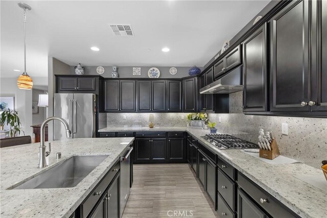 28934 Rangeview Dr, Murrieta, CA 92563 - kitchen with a sink, appliances with stainless steel finishes, under cabinet range hood, light stone counters, and recessed lighting