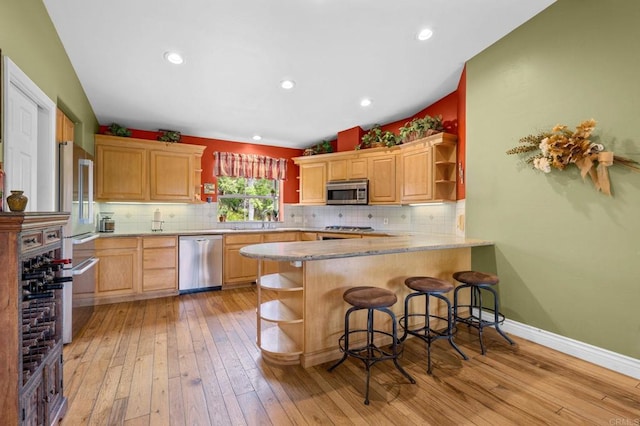 3161921 Via Puerta Del Sol, Bonsall, CA 92003 - kitchen featuring stainless steel appliances, open shelves, light wood finished floors, and a peninsula