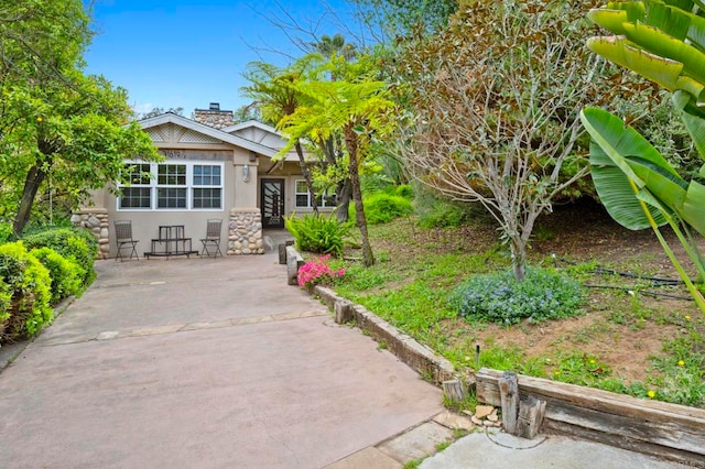3161921 Via Puerta Del Sol, Bonsall, CA 92003 - view of front of property with a chimney, stucco siding, and stone siding