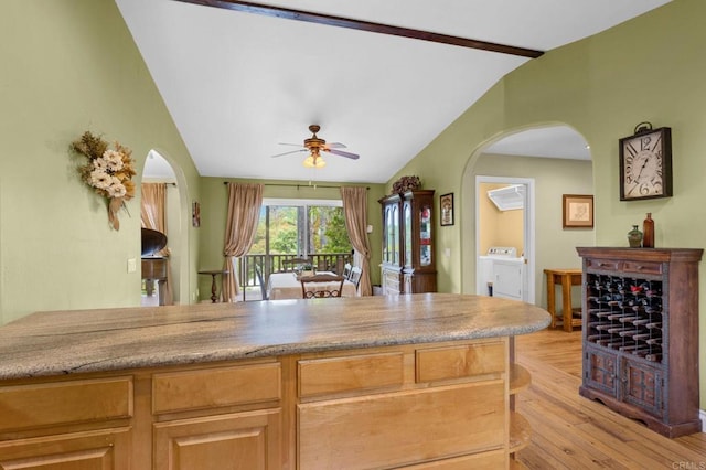 3161921 Via Puerta Del Sol, Bonsall, CA 92003 - kitchen featuring ceiling fan, independent washer and dryer, lofted ceiling with beams, and arched walkways