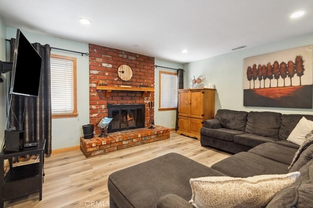 living room with recessed lighting, visible vents, wood finished floors, and a fireplace