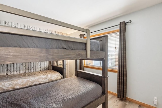 bedroom with wood finished floors and baseboards