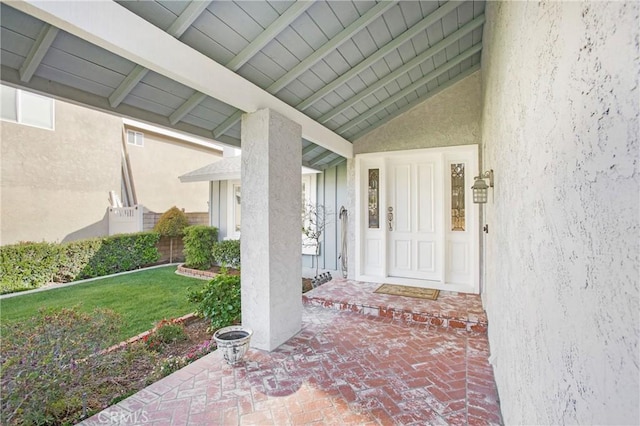 entrance to property with a lawn and stucco siding