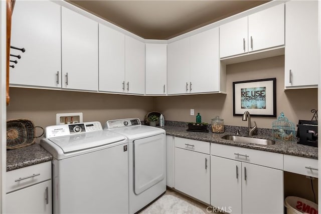 clothes washing area featuring washer and dryer, a sink, and cabinet space