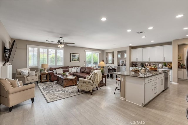 living room featuring visible vents, light wood-type flooring, recessed lighting, and a ceiling fan