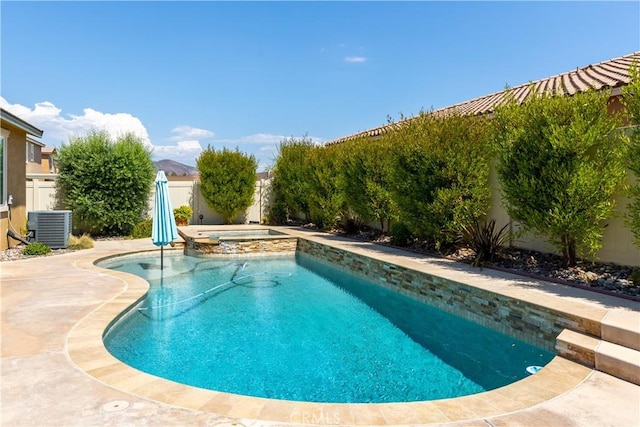 view of swimming pool featuring fence, central air condition unit, and a pool with connected hot tub