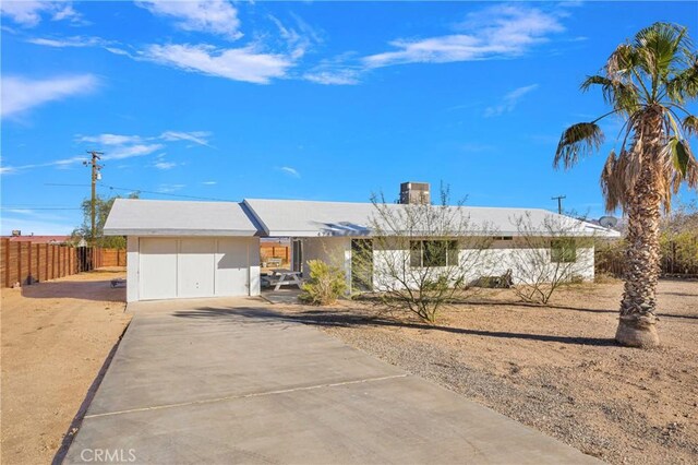 single story home featuring concrete driveway and fence