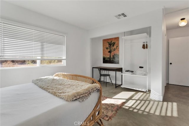 bedroom featuring concrete floors, visible vents, and a closet