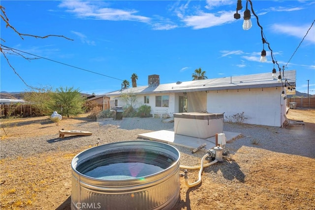 back of house with a hot tub