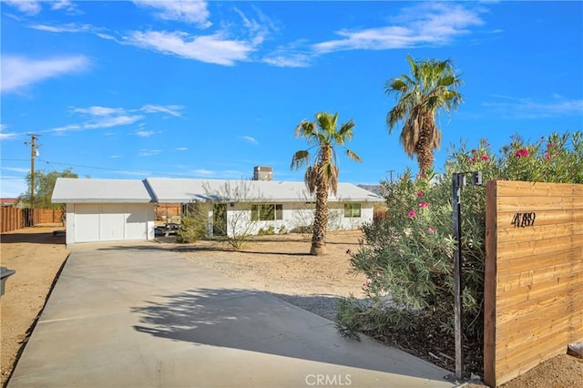 view of front of house featuring fence and concrete driveway