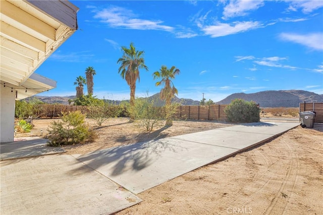 view of yard with a mountain view, a fenced backyard, and a patio area