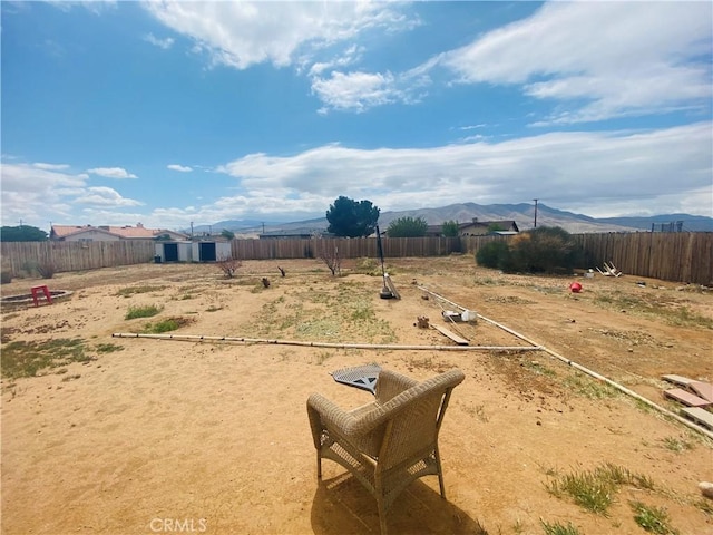 view of yard featuring fence and a mountain view