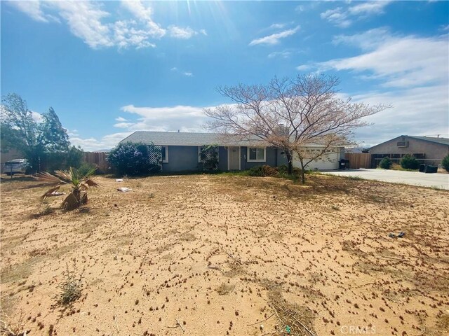 ranch-style house featuring fence and concrete driveway