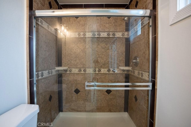full bath with toilet and a stall shower