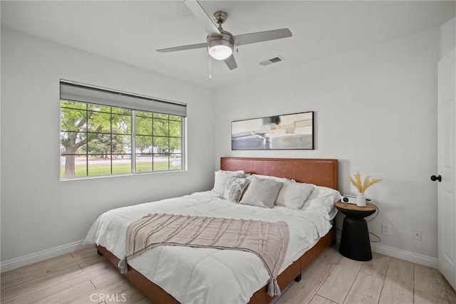 bedroom featuring visible vents, ceiling fan, wood finished floors, and baseboards