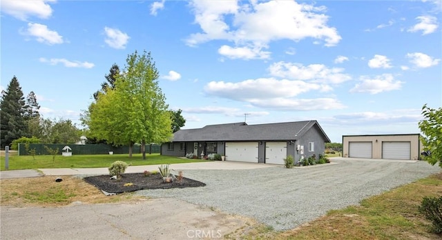 ranch-style house featuring fence, gravel driveway, and a front lawn