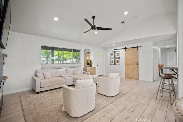 living area featuring light wood finished floors, recessed lighting, a barn door, a ceiling fan, and lofted ceiling