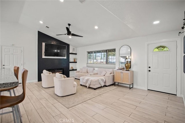 living room with recessed lighting, ceiling fan, lofted ceiling, and light wood-style floors