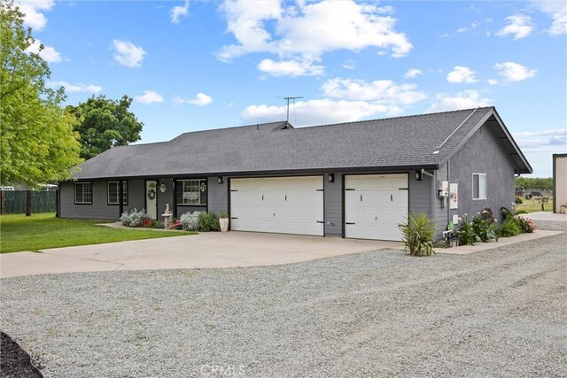 ranch-style home featuring a front lawn, driveway, roof with shingles, an attached garage, and fence