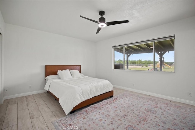 bedroom with wood finished floors, a ceiling fan, and baseboards