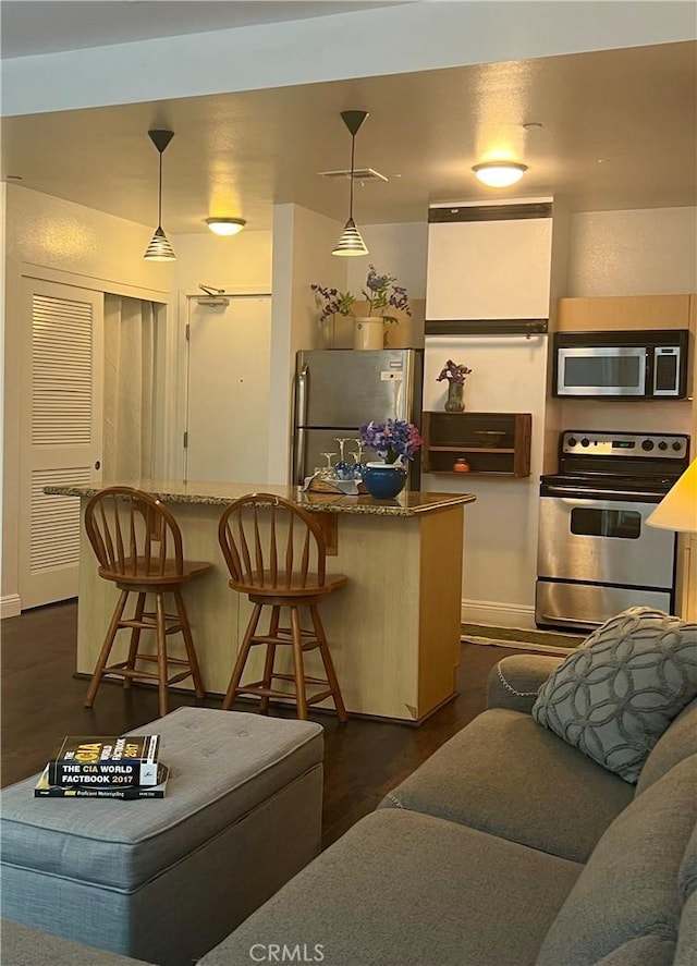 630 W 6th St Unit 611, Los Angeles, CA 90017 - kitchen with stainless steel appliances, baseboards, a breakfast bar area, and decorative light fixtures