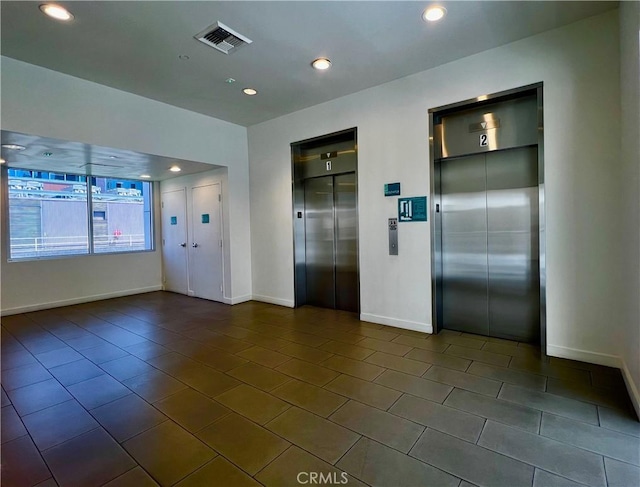 630 W 6th St Unit 611, Los Angeles, CA 90017 - unfurnished room featuring elevator, baseboards, dark tile patterned flooring, and recessed lighting