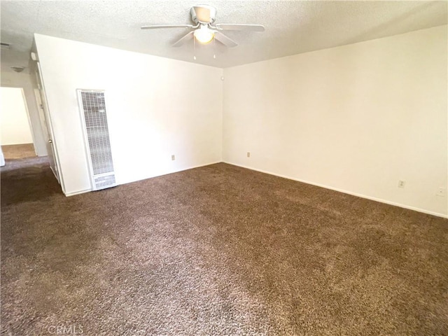 18225 Casaba Rd, Adelanto, CA 92301 - spare room featuring a textured ceiling, a heating unit, ceiling fan, and dark carpet