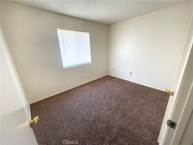 18225 Casaba Rd, Adelanto, CA 92301 - empty room featuring baseboards, dark carpet, and a textured ceiling
