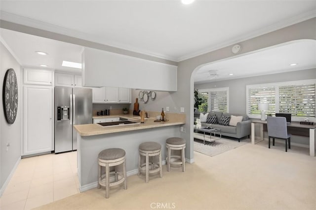 kitchen with crown molding, light countertops, stainless steel fridge with ice dispenser, a peninsula, and white cabinetry
