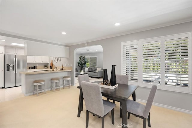 dining room with a healthy amount of sunlight, arched walkways, ornamental molding, and recessed lighting