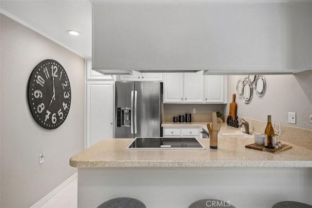 kitchen with white cabinets, light countertops, black electric cooktop, a peninsula, and stainless steel refrigerator with ice dispenser