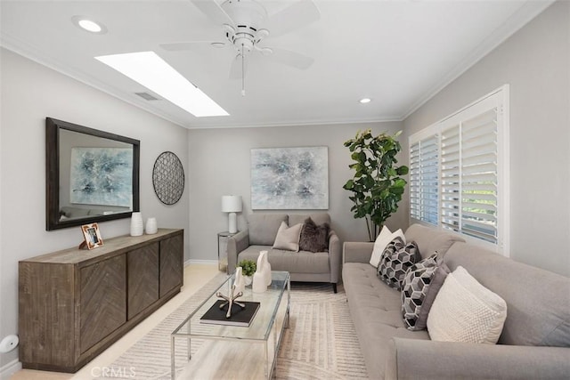 living area featuring ceiling fan, visible vents, a skylight, ornamental molding, and recessed lighting