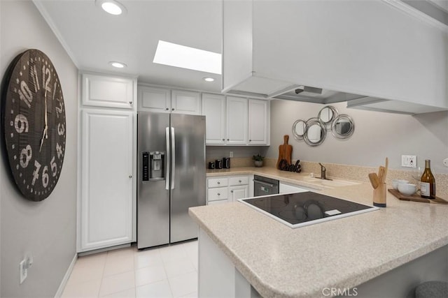 kitchen featuring a sink, stainless steel appliances, recessed lighting, a peninsula, and a skylight