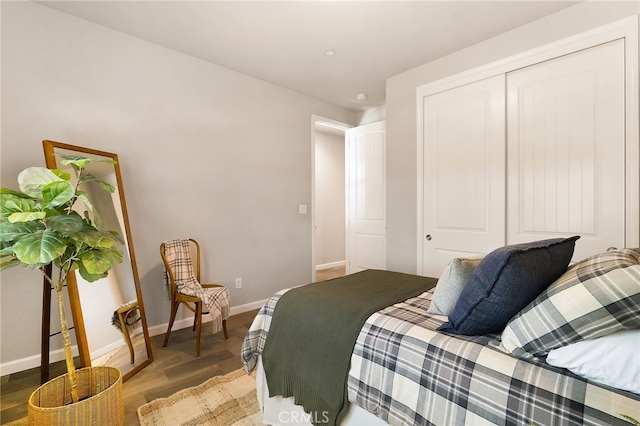 bedroom featuring baseboards, wood finished floors, and a closet