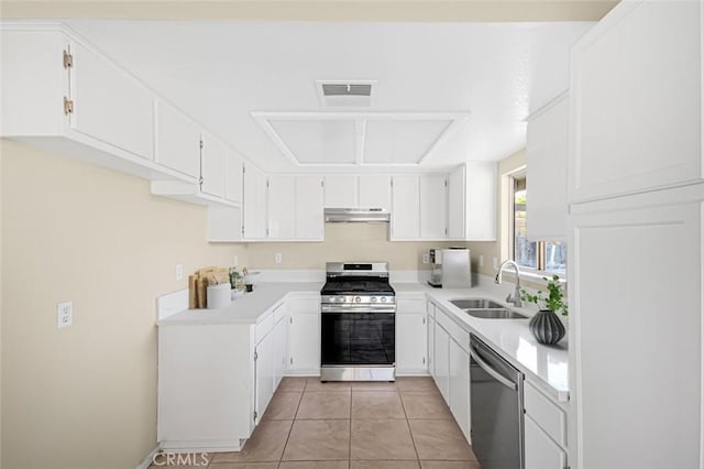 kitchen with under cabinet range hood, appliances with stainless steel finishes, light countertops, a sink, and visible vents