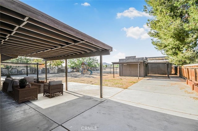 view of patio / terrace featuring an outdoor living space, a fenced backyard, and a playground