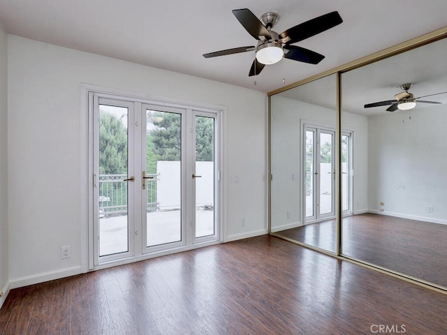 unfurnished room with wood finished floors, a healthy amount of sunlight, and ceiling fan