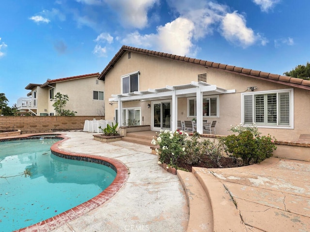 back of house with stucco siding, fence, a fenced in pool, a patio area, and a pergola