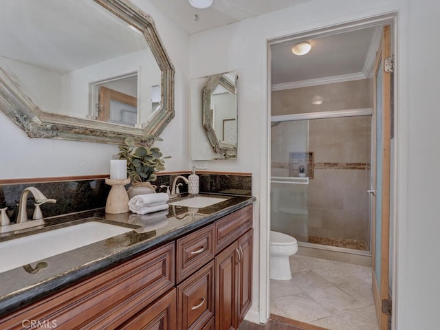 bathroom with double vanity, toilet, a stall shower, and a sink