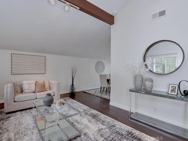 living area with wood finished floors, visible vents, vaulted ceiling, and baseboards