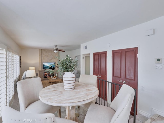 dining space featuring light tile patterned floors, a ceiling fan, visible vents, and baseboards