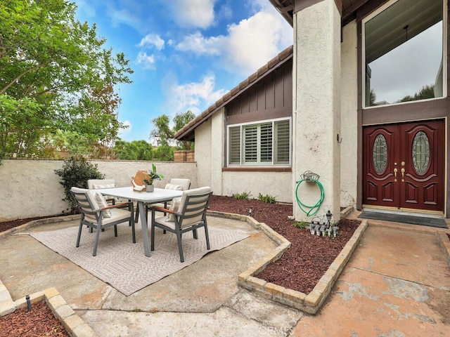 view of patio with outdoor dining space and fence