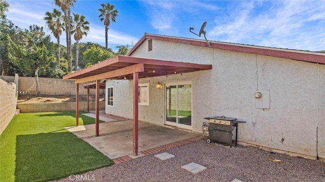 rear view of property featuring a pergola, stucco siding, a fenced backyard, a patio area, and a yard