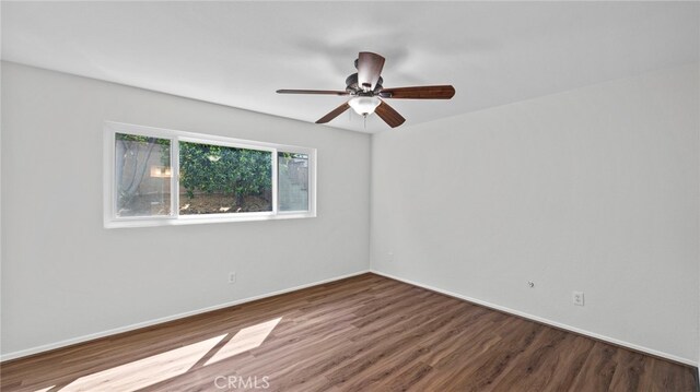 unfurnished room featuring a ceiling fan, baseboards, and wood finished floors