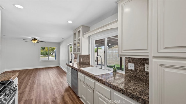 kitchen featuring dark wood-style flooring, ceiling fan, a sink, tile counters, and stainless steel appliances