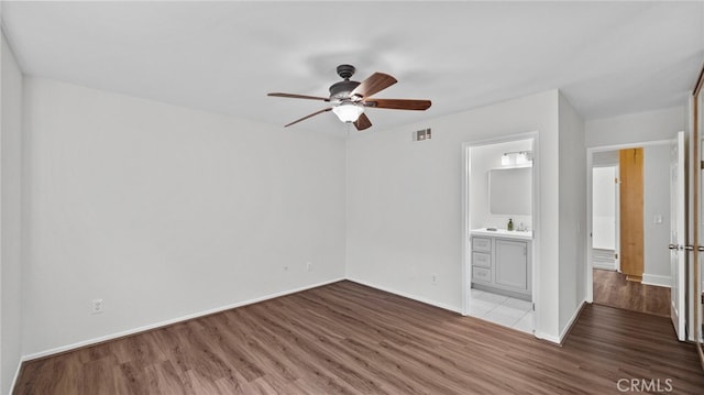 unfurnished bedroom featuring baseboards, visible vents, and wood finished floors