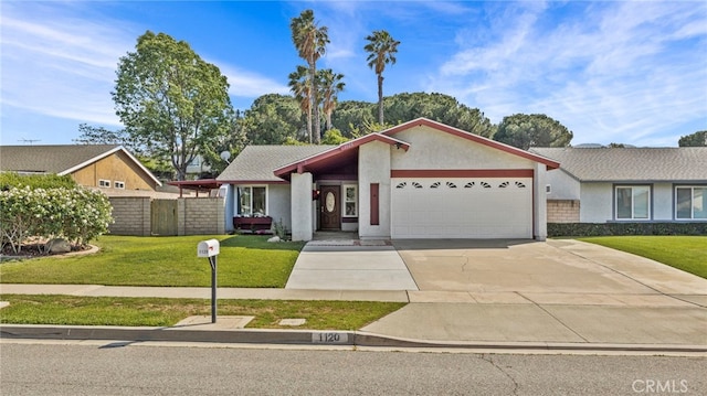 mid-century inspired home with fence, an attached garage, driveway, and a front lawn
