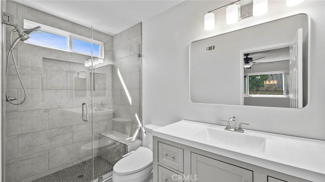 full bath with vanity, ceiling fan, toilet, and a shower stall